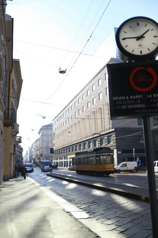 a city bus next to a street with cars and buildings