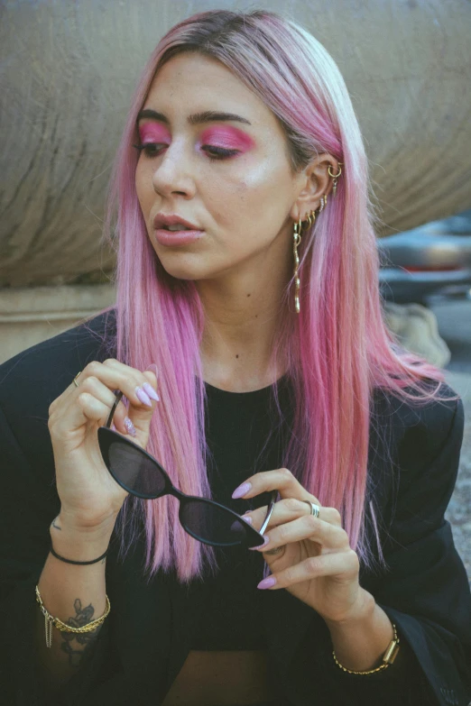 a woman with pink hair has some pink eyeliner