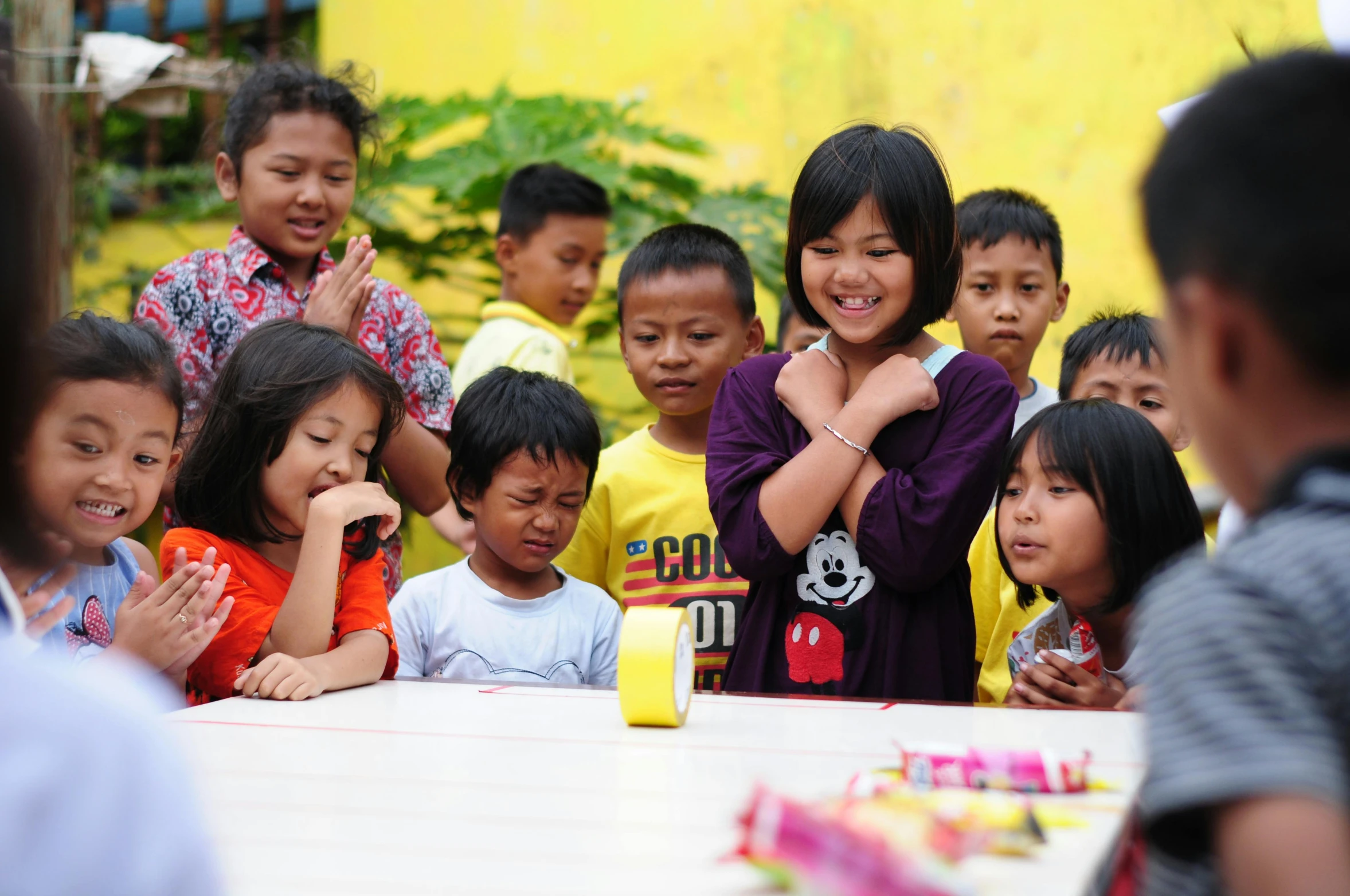 a group of s at a table clapping together