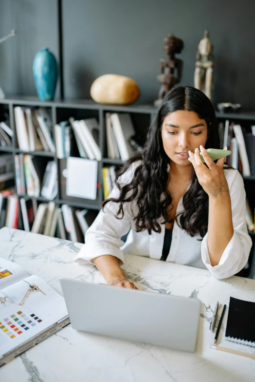 a woman that is sitting at a desk with a laptop