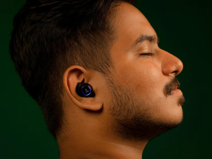 a man wearing earrings with a blue ring