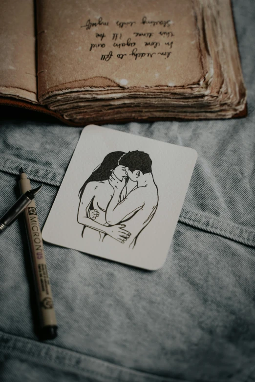 a couple emcing and holding each other next to an open book