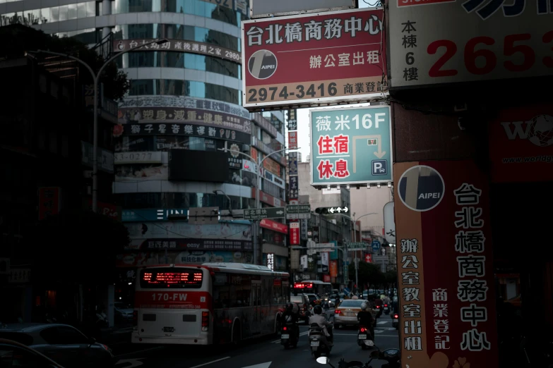 a city street with cars and motorcycles with asian signs on the buildings