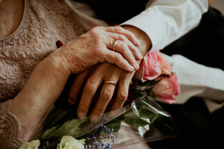 a couple holding each other over a bouquet of flowers