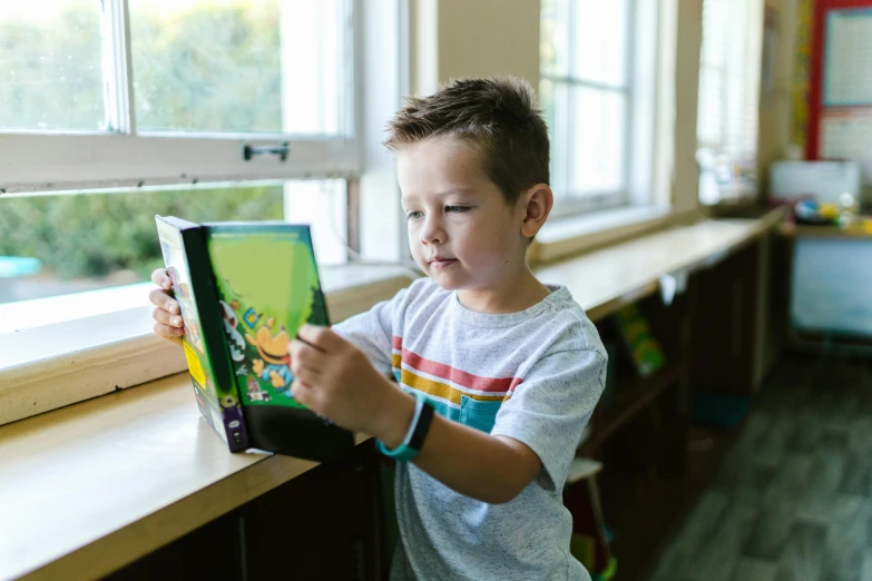 a  is looking at a children's book in his classroom