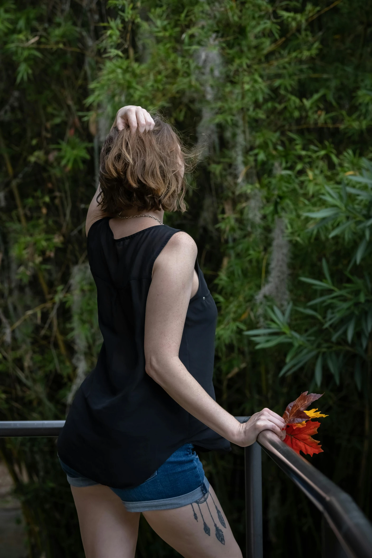 a woman in shorts and a black tank top is on the steps