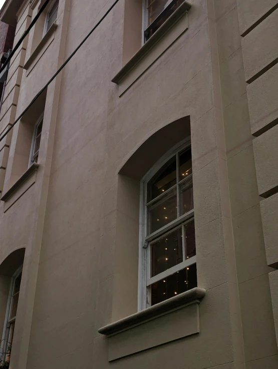 a building with white windows has a clock on the side