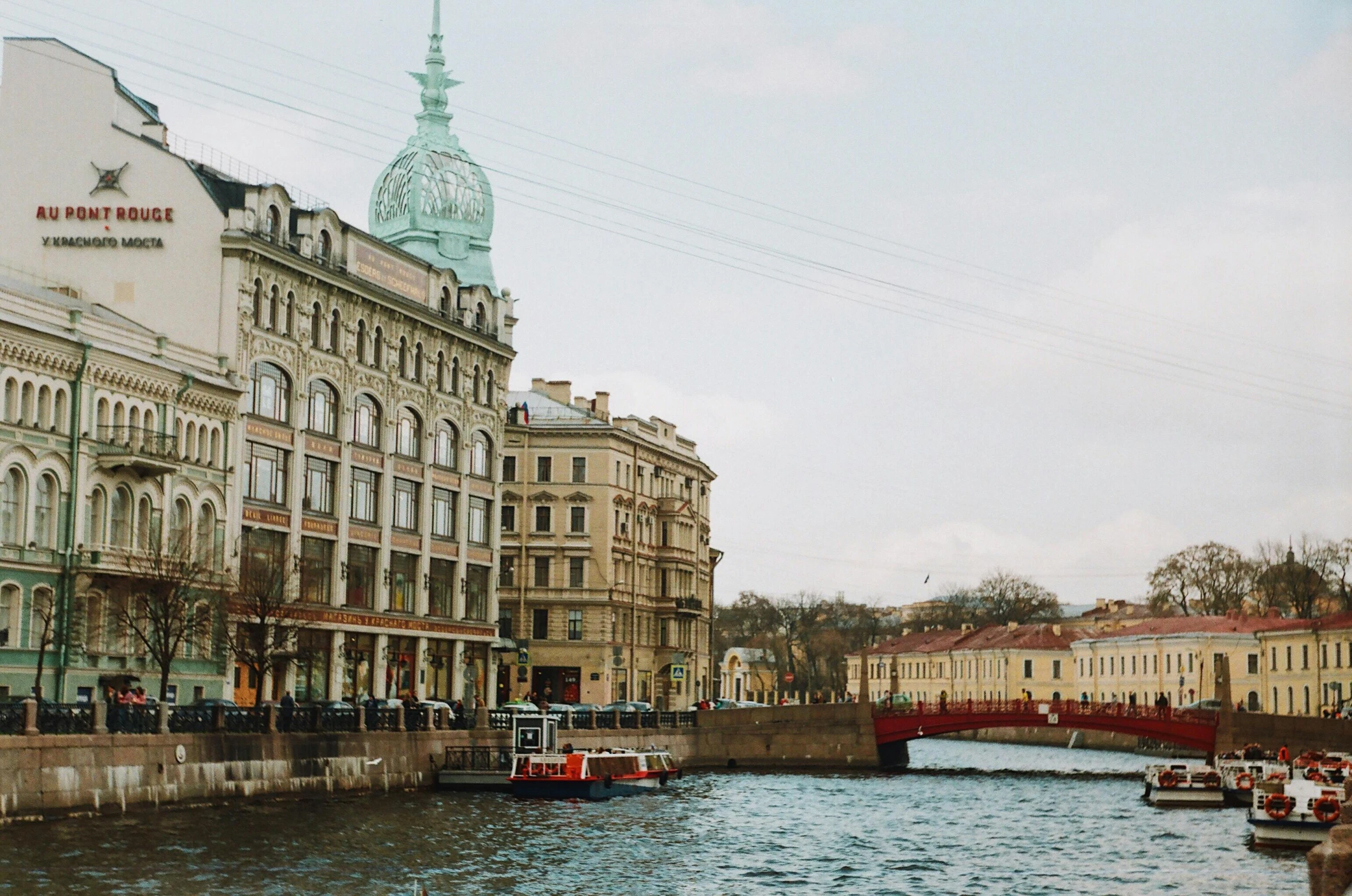 old buildings are along the water with a bridge over it