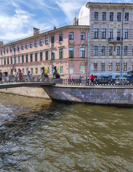 people riding bicycles on a bridge over a river