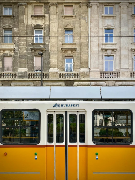 a very big yellow and white bus on the street