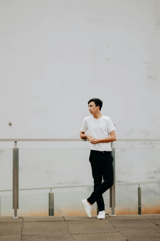 a man standing next to a railing near a building