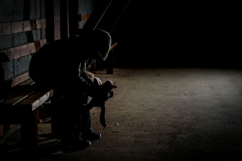 a person sitting on a bench alone, with dark background