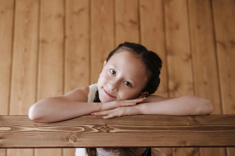 a girl in a room with wooden floors and a table