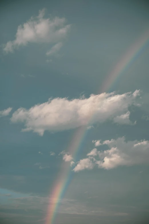 two rainbows flying under the clouds and the sun