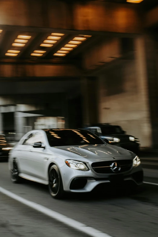 the front end of a silver mercedes in front of two other vehicles