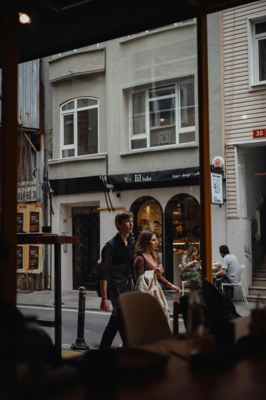 the man and woman are standing in front of the restaurant