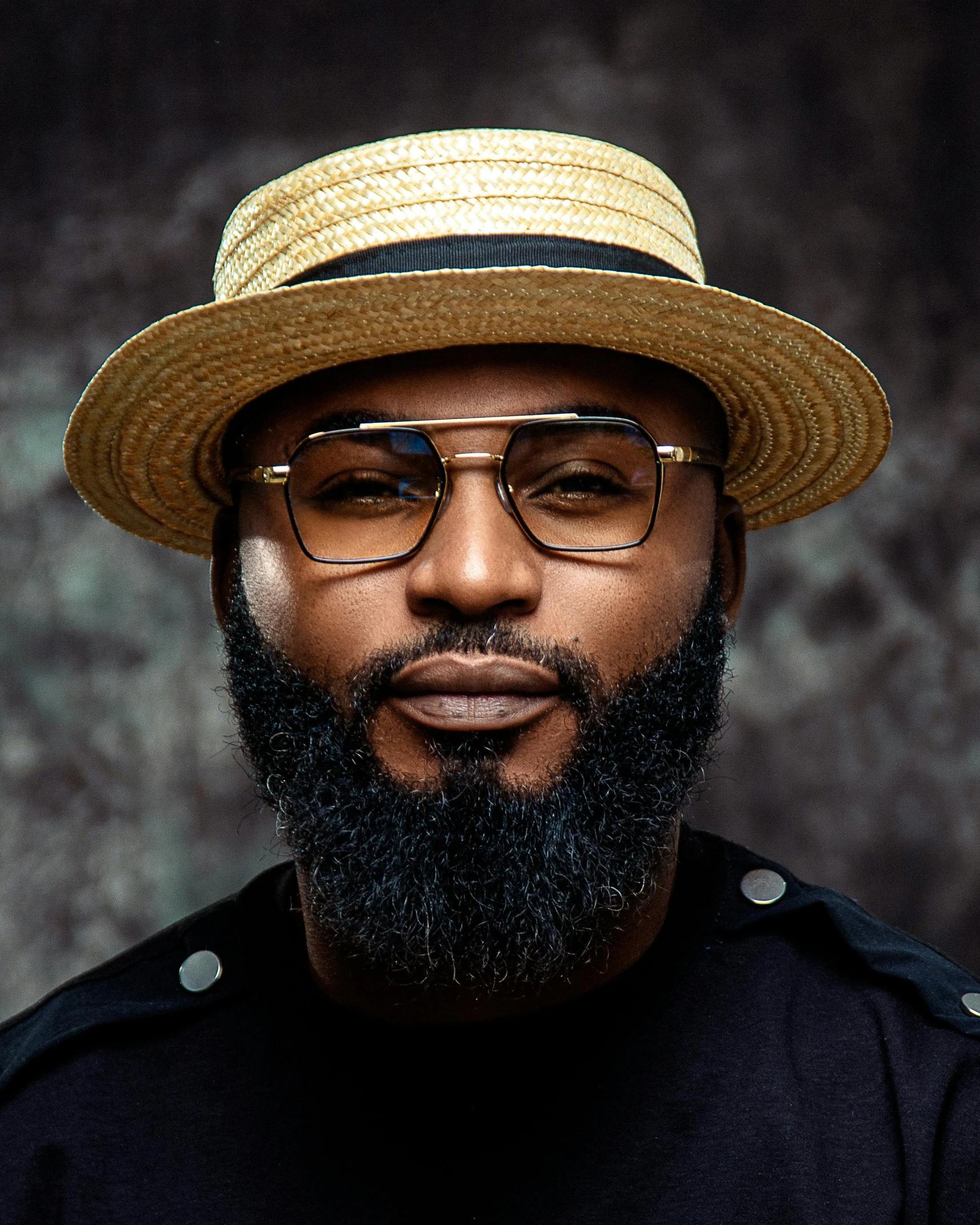 a man with a black beard wearing glasses and a hat