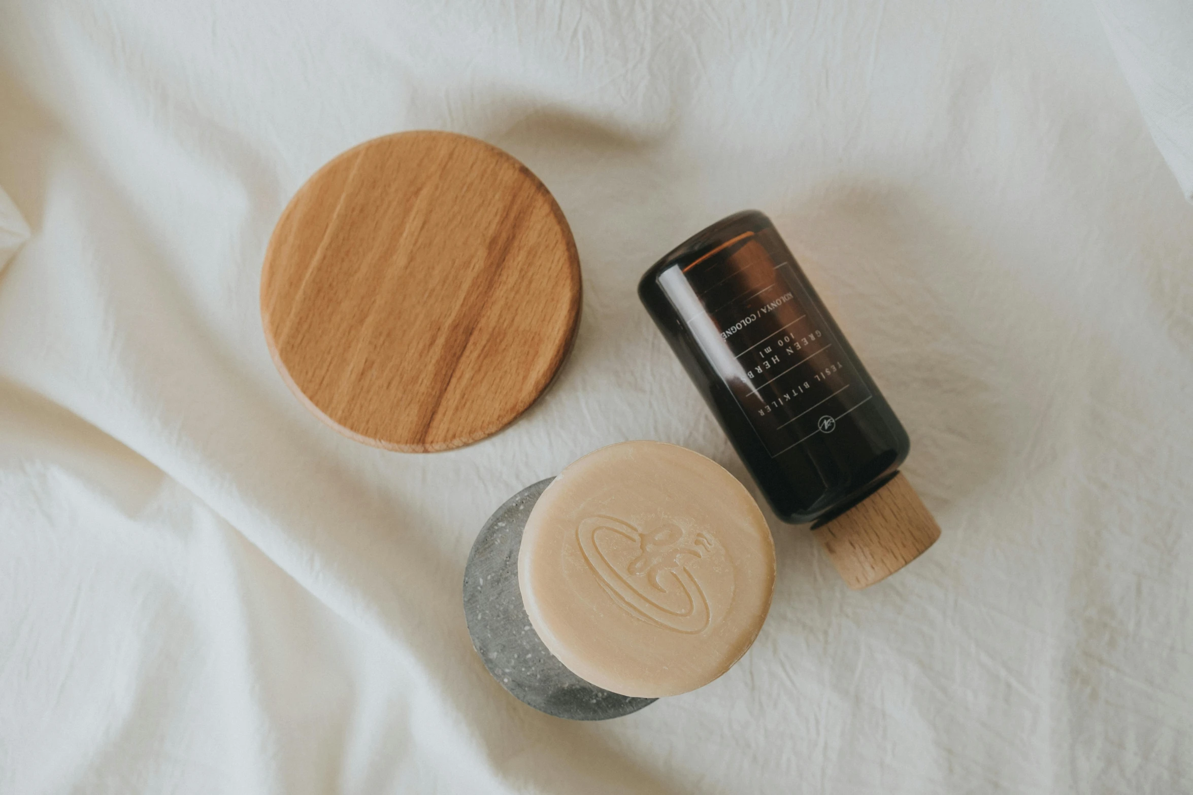 a wood candle next to a metal and glass container