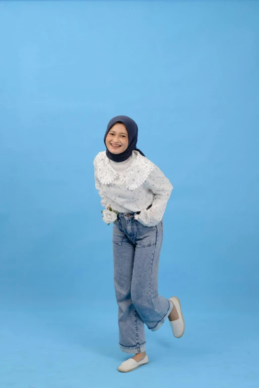 a young woman wearing jeans and a top posing for the camera