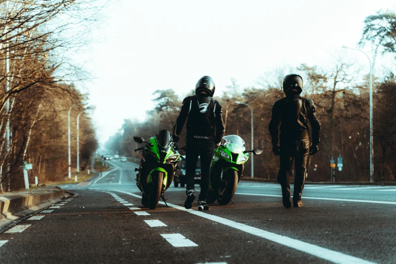 two men walking down the road next to some parked motorcycles