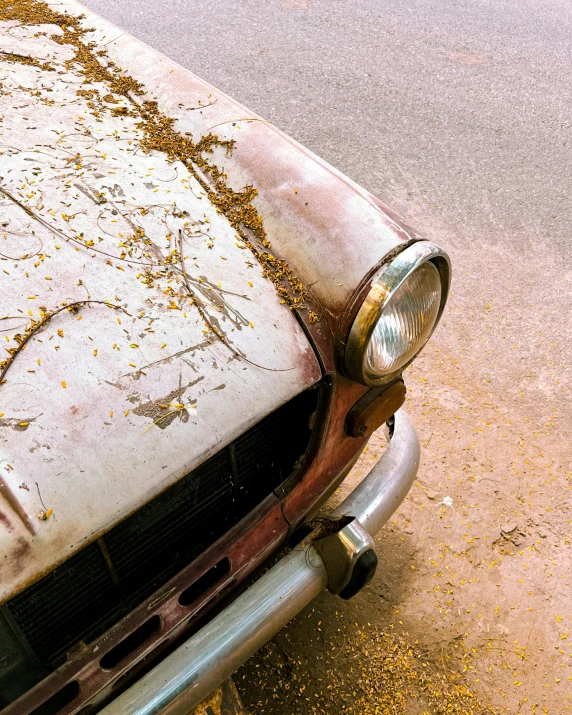 a dirty car parked on a street and covered in dirt