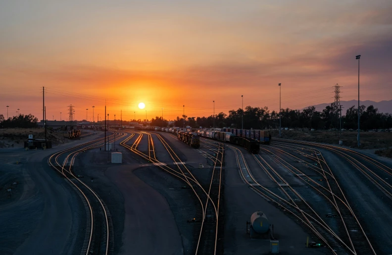 a sunset over railroad tracks in the middle of nowhere