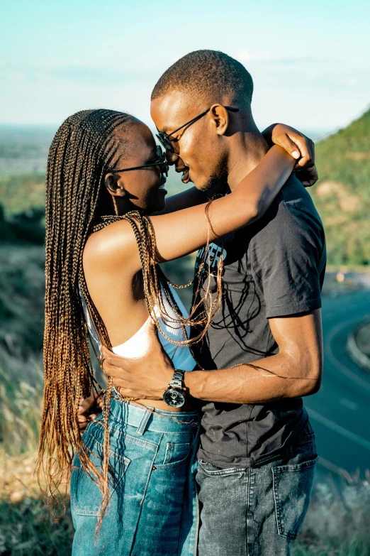 two people standing together in the grass hugging