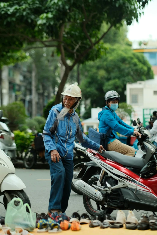 a man on a motor bike with another standing next to it