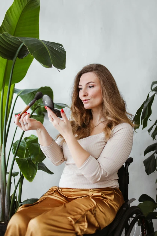 a woman sits in a chair and holds scissors