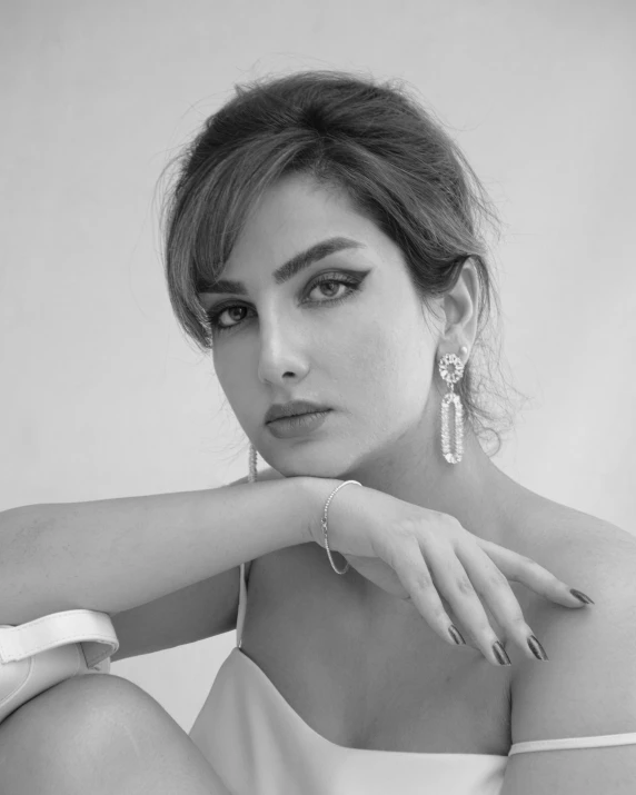 a woman in white clothing and silver earrings