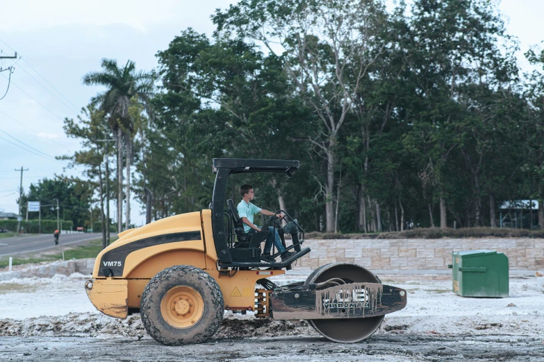 there is a construction truck in the driveway and another bulldozer is behind