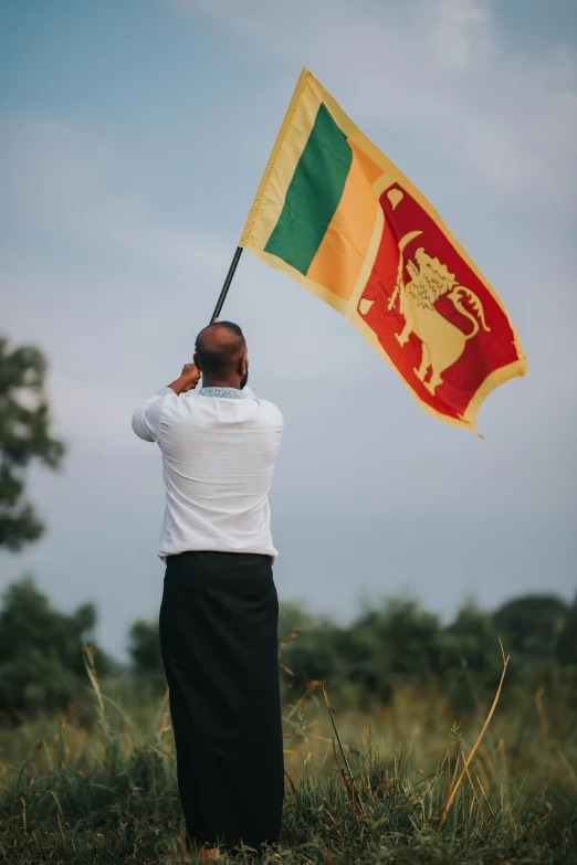 a man standing in a field holding a flag