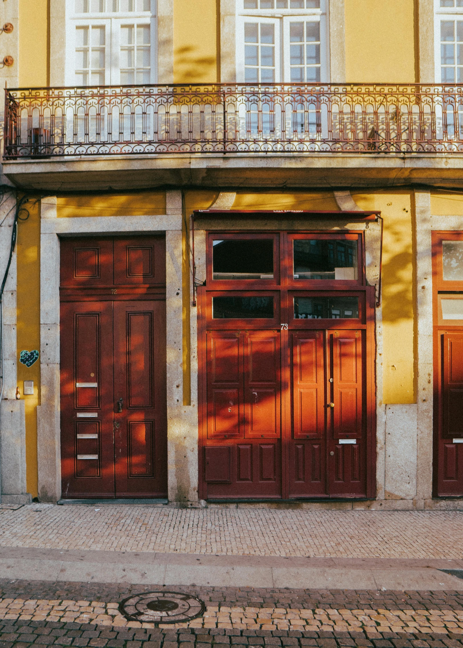 a man riding a bike past two building doors