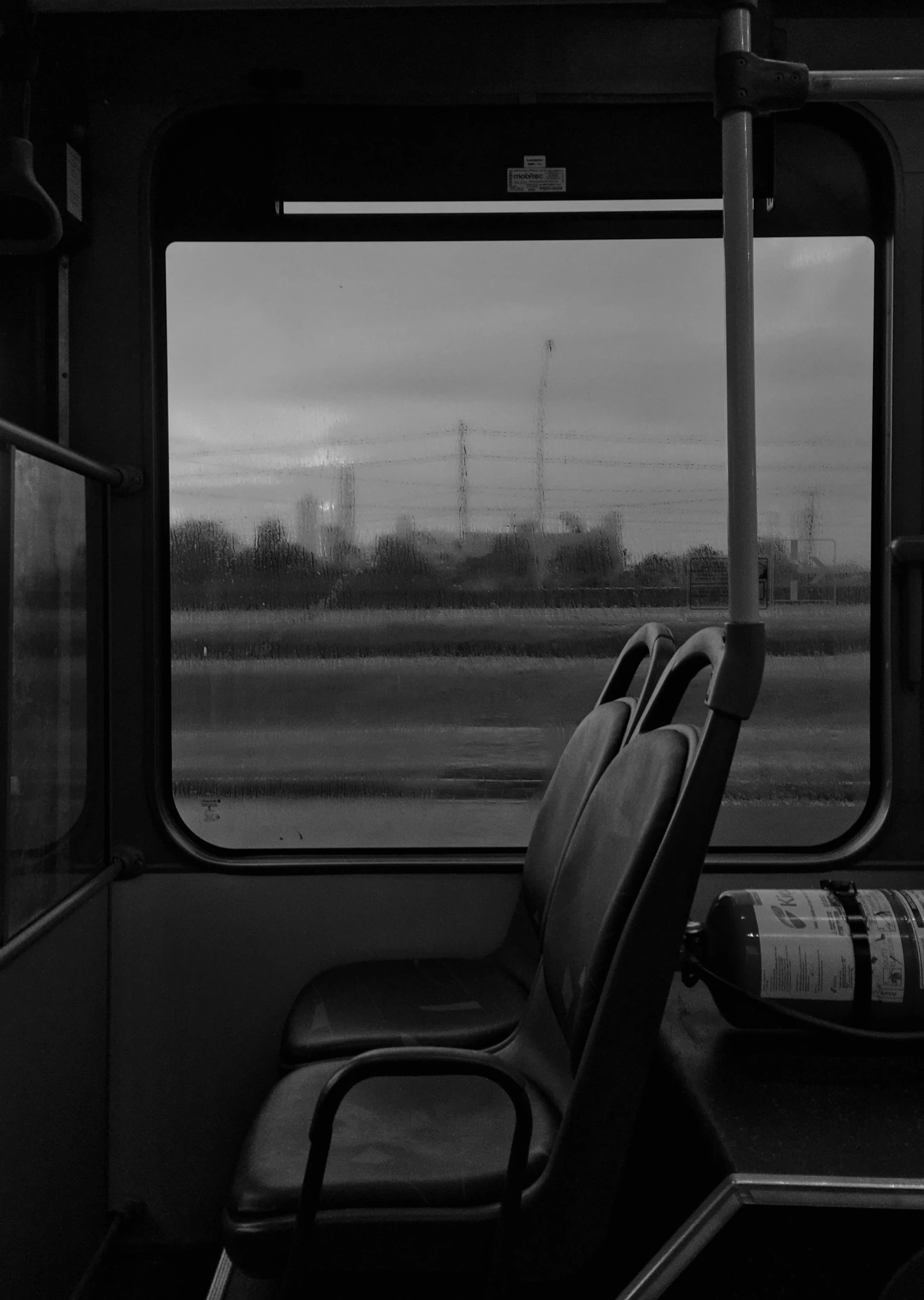 a black and white image of an empty seat on a train