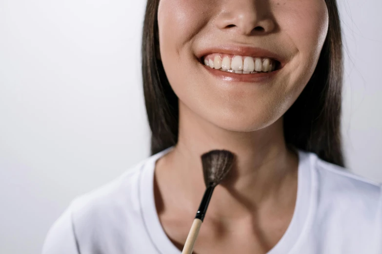 smiling woman with makeup brush in her hand