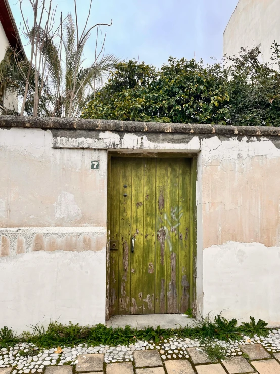 a wooden door and brick walkway next to a house