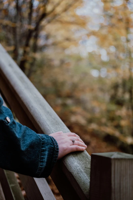 a person's hand is resting on the railing outside