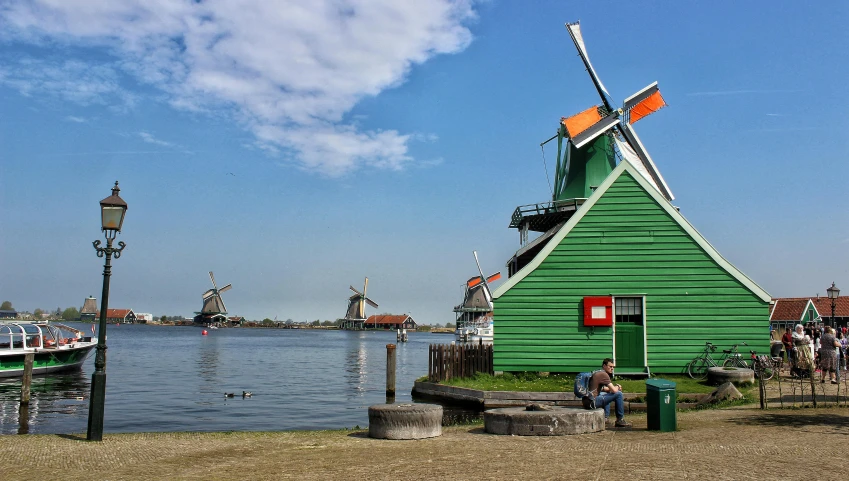 windmills on the shore of a lake surrounded by buildings