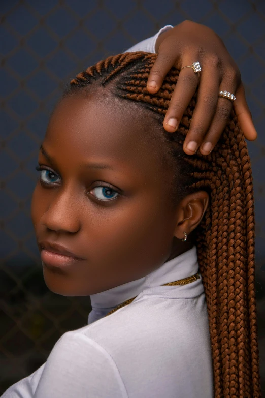 woman with very long ids styled into ponytail, against a wall