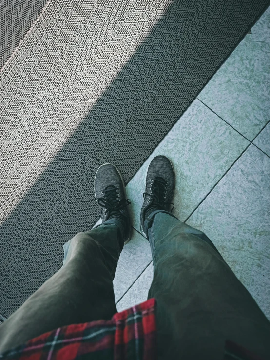 a pair of shoes standing next to each other near tile flooring