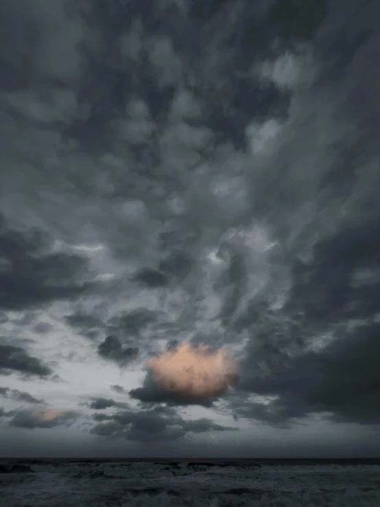 a sky filled with clouds above the ocean