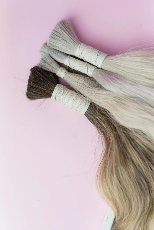 a grey wig laying on top of two blond hair bundles