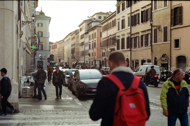 people are walking on the sidewalk of a city street