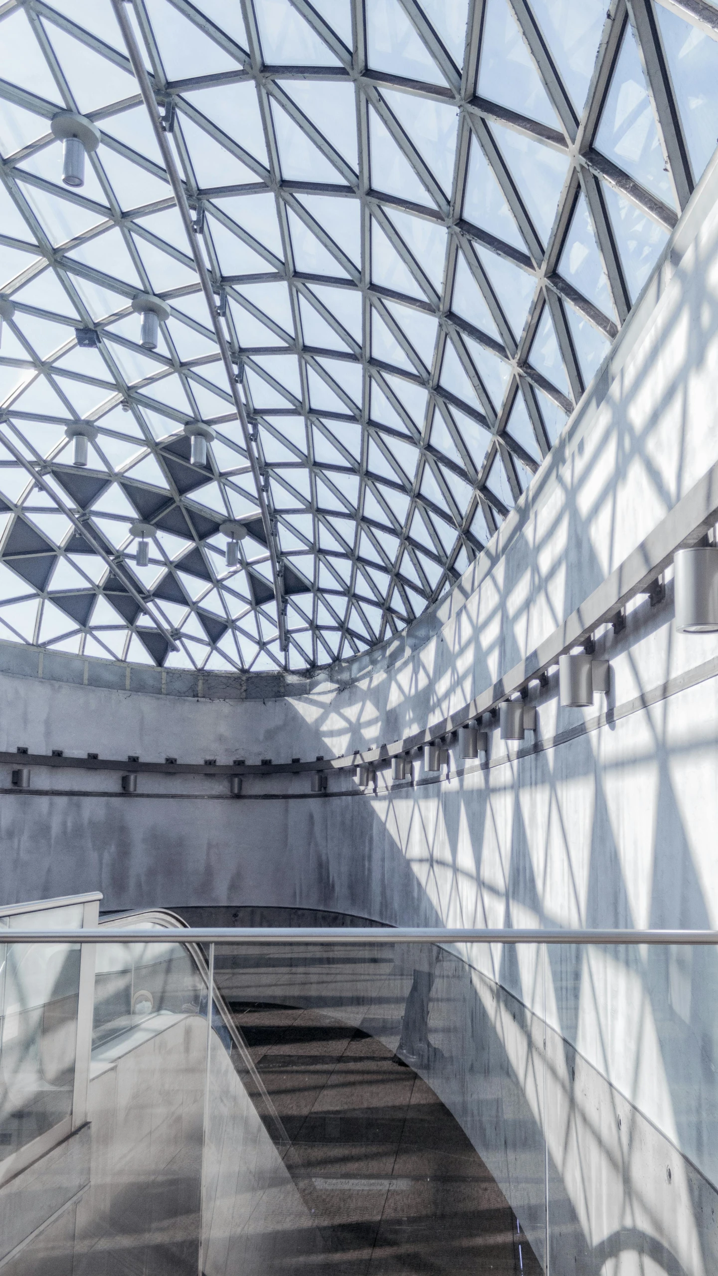 some stairs going up and down to an area with a glass ceiling