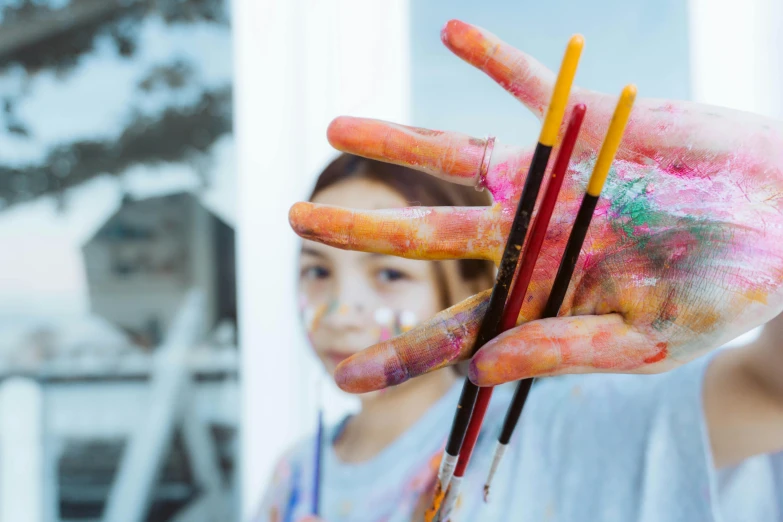 a girl shows her hand painted with paint