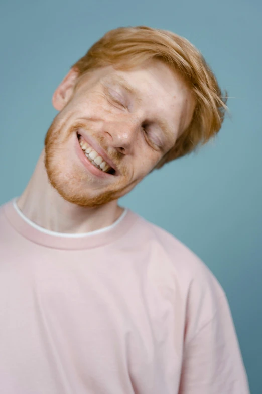 there is a smiling man wearing a pink shirt