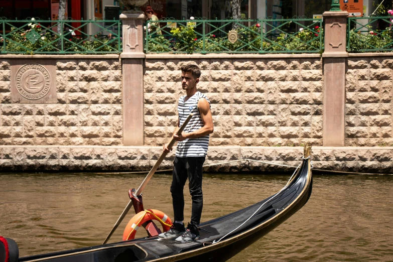 a man stands on a boat with his oar