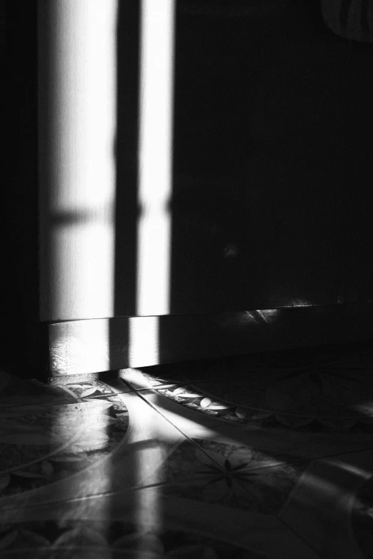 a black and white po of a light coming through an open door