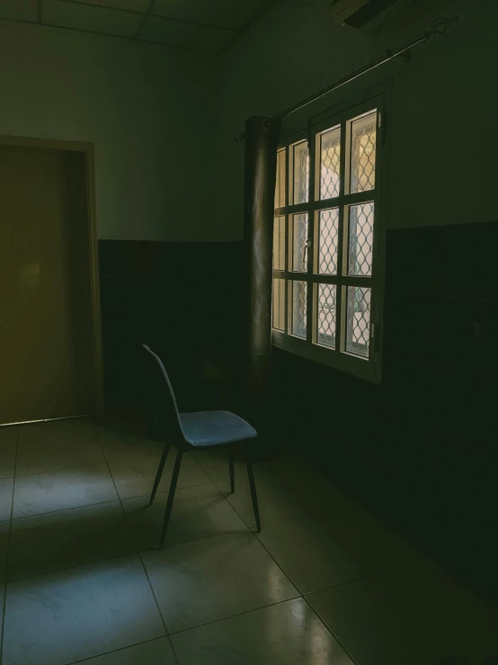 an empty chair in a dimly lit room with large windows