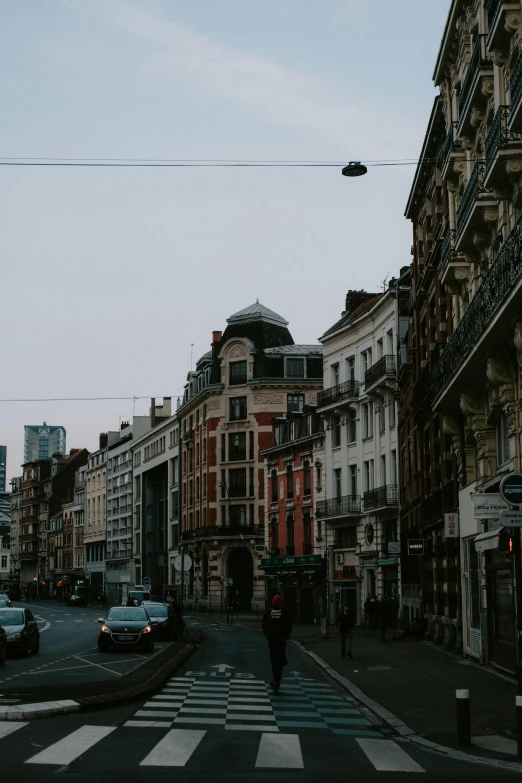 an intersection is shown with people, cars, and buildings